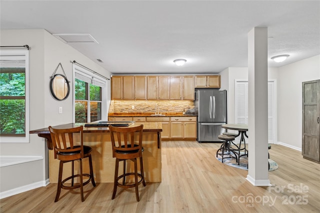 200 Lake Club Dr, Nebo, NC 28761 - kitchen with freestanding refrigerator, light wood-style floors, backsplash, a kitchen breakfast bar, and a peninsula