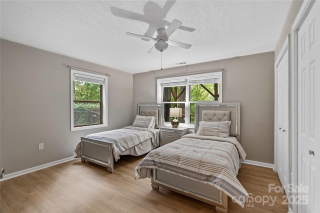 200 Lake Club Dr, Nebo, NC 28761 - bedroom featuring multiple windows, wood finished floors, a textured ceiling, and ceiling fan