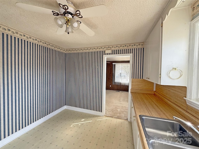 3412 1st Avenue Cir NW, Hickory, NC 28601 - kitchen featuring a textured ceiling, ceiling fan, light flooring, and wallpapered walls