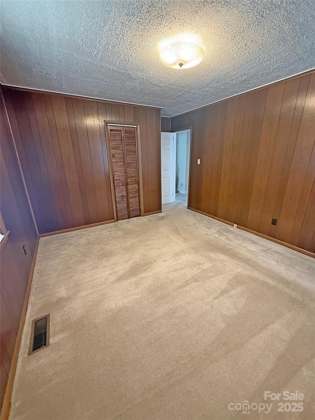 3412 1st Avenue Cir NW, Hickory, NC 28601 - unfurnished bedroom with carpet floors, wood walls, a textured ceiling, and a closet