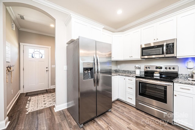 2526 Snow Creek Rd NE, Hickory, NC 28601 - kitchen featuring appliances with stainless steel finishes, crown molding, light stone counters, wood finished floors, and arched walkways