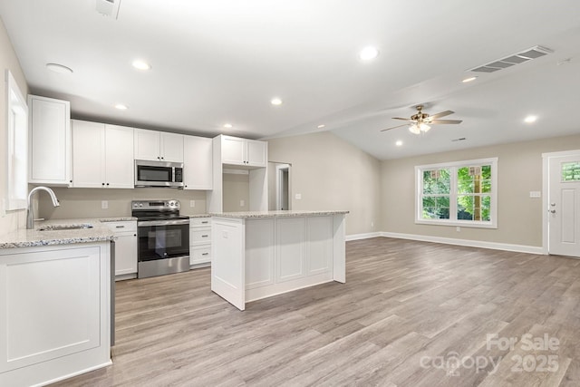 1234 Goodnight Ln, Kannapolis, NC 28081 - kitchen featuring stainless steel appliances, vaulted ceiling, a ceiling fan, white cabinets, and light wood-style floors