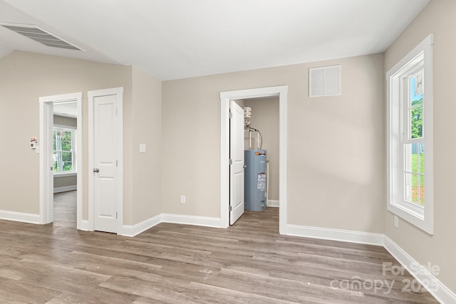 1234 Goodnight Ln, Kannapolis, NC 28081 - spare room with electric water heater, wood finished floors, and lofted ceiling