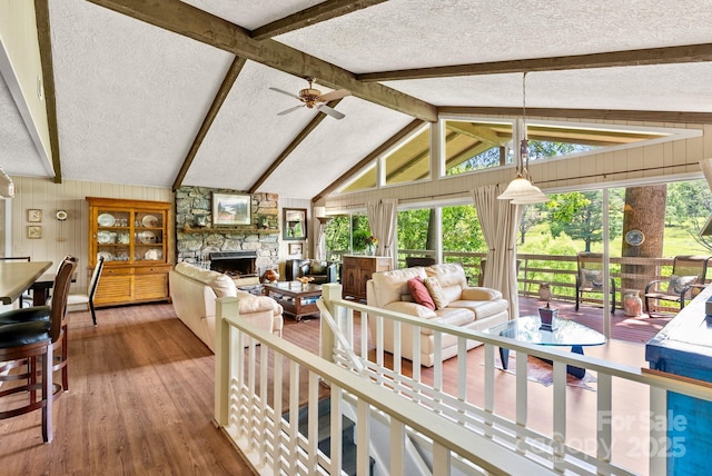 386 Country Club Dr Unit C6, Canton, NC 28716 - living area featuring a stone fireplace, a textured ceiling, wood finished floors, ceiling fan, and wooden walls