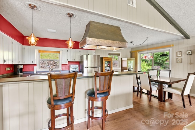 386 Country Club Dr Unit C6, Canton, NC 28716 - kitchen with freestanding refrigerator, a textured ceiling, dark countertops, wood finished floors, and a peninsula