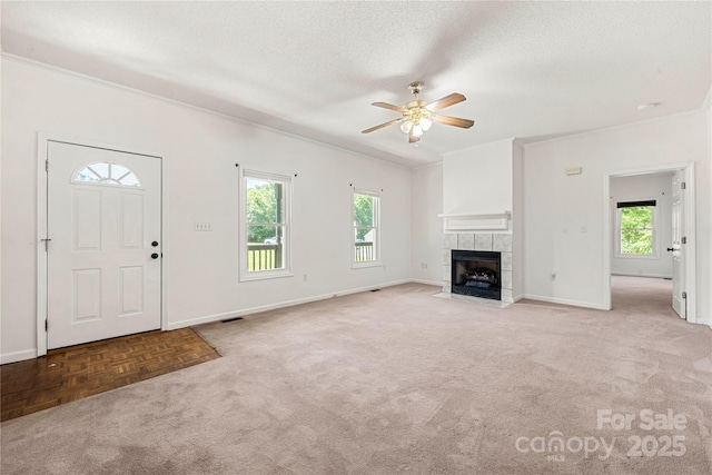 814 Carved Oak Ct, York, SC 29745 - unfurnished living room featuring ceiling fan, plenty of natural light, carpet, a tiled fireplace, and a textured ceiling