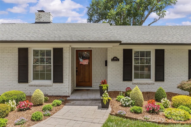 5501 Murrayhill Rd, Charlotte, NC 28210 - doorway to property with a chimney, a shingled roof, brick siding, and covered porch