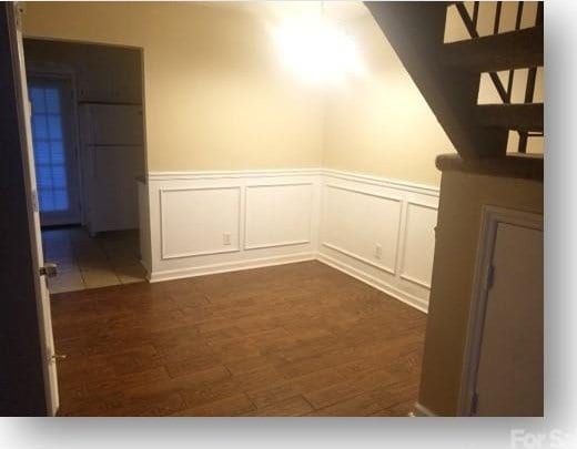 153 W End St, Chester, SC 29706 - empty room with a wainscoted wall, dark wood finished floors, and a decorative wall