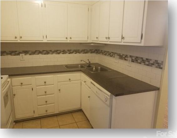 153 W End St, Chester, SC 29706 - kitchen with white dishwasher, dark countertops, white cabinets, and light tile patterned floors