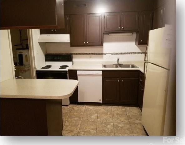 153 W End St, Chester, SC 29706 - kitchen with white appliances, extractor fan, light countertops, dark brown cabinets, and a peninsula