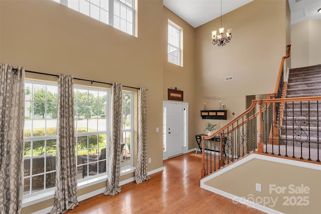 2004 Onotoa Dr, Indian Trail, NC 28079 - foyer featuring stairway, wood finished floors, a chandelier, healthy amount of natural light, and a high ceiling