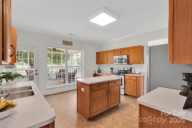 2004 Onotoa Dr, Indian Trail, NC 28079 - kitchen featuring appliances with stainless steel finishes, light countertops, a center island, brown cabinetry, and light floors