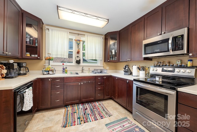 206 Mitchell Ave, Salisbury, NC 28144 - kitchen with stainless steel appliances, light countertops, glass insert cabinets, and dark brown cabinets