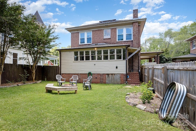 206 Mitchell Ave, Salisbury, NC 28144 - rear view of house with a fenced backyard, a chimney, an outdoor fire pit, and brick siding