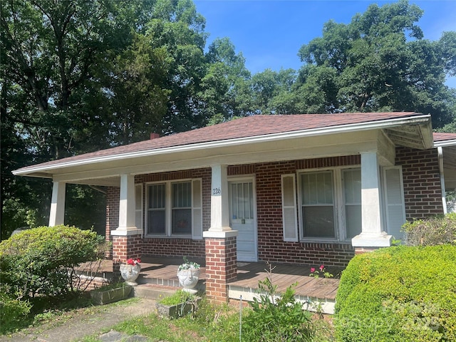 226 S Morrow Ave, Albemarle, NC 28001 - view of front of house with brick siding, a porch, and roof with shingles