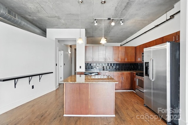 505 E 6th St Unit 908, Charlotte, NC 28202 - kitchen with stainless steel appliances, wood finished floors, backsplash, a center island, and light stone countertops