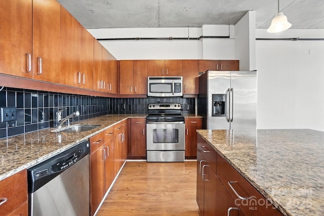 505 E 6th St Unit 908, Charlotte, NC 28202 - kitchen featuring stainless steel appliances, light wood-style flooring, brown cabinetry, and stone countertops