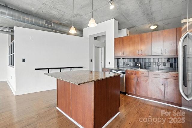 505 E 6th St Unit 908, Charlotte, NC 28202 - kitchen with dishwasher, wood finished floors, light stone counters, decorative backsplash, and a center island