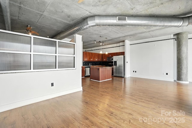 505 E 6th St Unit 908, Charlotte, NC 28202 - unfurnished living room featuring baseboards and wood finished floors