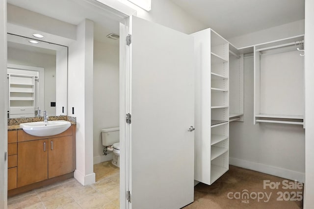 505 E 6th St Unit 908, Charlotte, NC 28202 - bathroom with vanity, a spacious closet, and recessed lighting