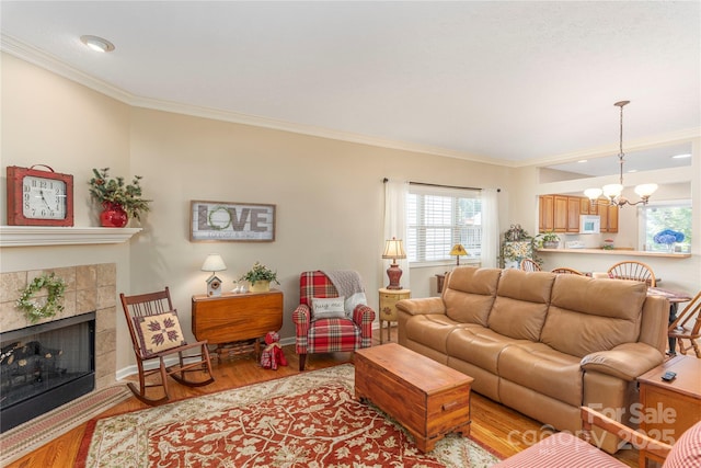 190 Shaws Creek Farm Rd, Hendersonville, NC 28739 - living room with crown molding, light wood finished floors, a chandelier, plenty of natural light, and a tiled fireplace