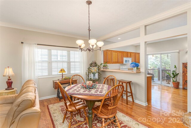 190 Shaws Creek Farm Rd, Hendersonville, NC 28739 - dining room with a chandelier, crown molding, and light wood-style floors