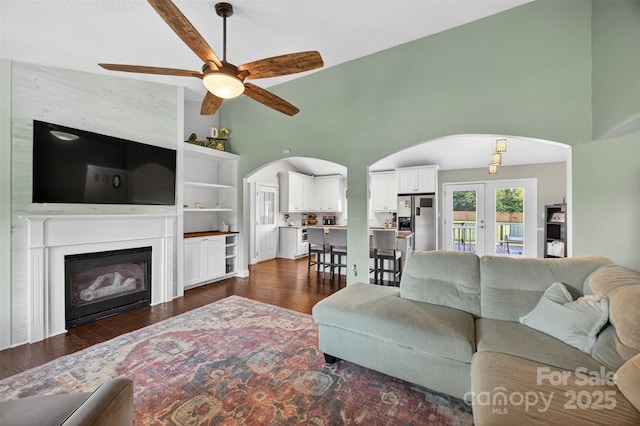 106 Abbey Cir, Salisbury, NC 28147 - living room featuring arched walkways, high vaulted ceiling, ceiling fan, dark wood-style flooring, and a glass covered fireplace