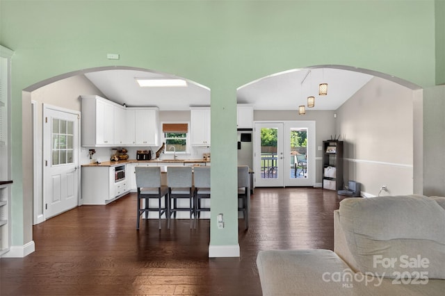 106 Abbey Cir, Salisbury, NC 28147 - kitchen with open floor plan, white cabinetry, dark wood-style floors, a breakfast bar, and lofted ceiling