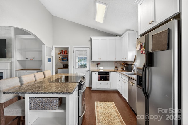 106 Abbey Cir, Salisbury, NC 28147 - kitchen with stainless steel appliances, lofted ceiling, a breakfast bar area, dark wood finished floors, and white cabinetry