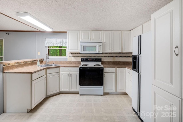 6 Kims Ct, Clyde, NC 28721 - kitchen featuring white appliances, a peninsula, a textured ceiling, light flooring, and white cabinetry
