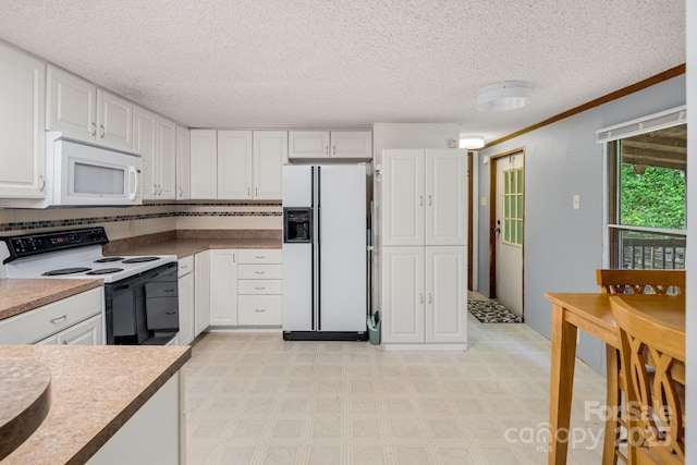 6 Kims Ct, Clyde, NC 28721 - kitchen featuring white appliances, white cabinetry, a textured ceiling, light flooring, and ornamental molding