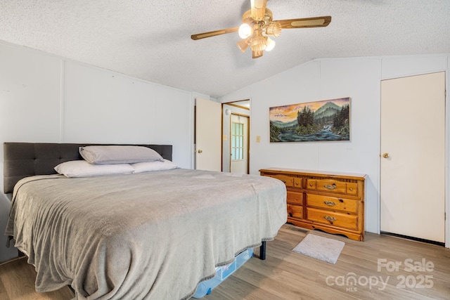 6 Kims Ct, Clyde, NC 28721 - bedroom with vaulted ceiling, a textured ceiling, wood finished floors, and ceiling fan