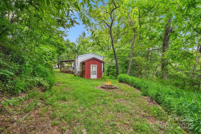 6 Kims Ct, Clyde, NC 28721 - view of green lawn with an outdoor fire pit and an outbuilding