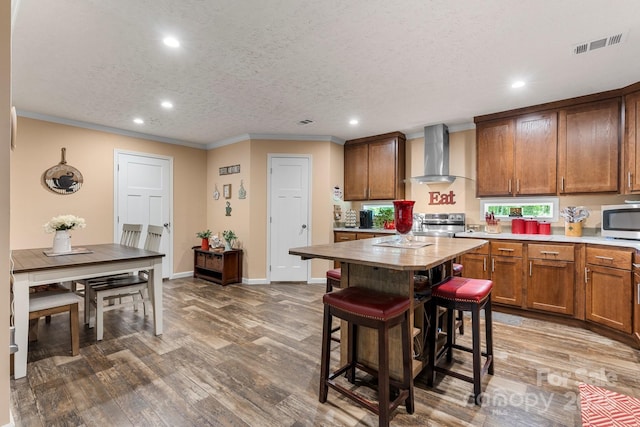 200 Vista Pointe Dr, Stony Point, NC 28678 - kitchen featuring wall chimney exhaust hood, stainless steel appliances, recessed lighting, ornamental molding, and brown cabinets