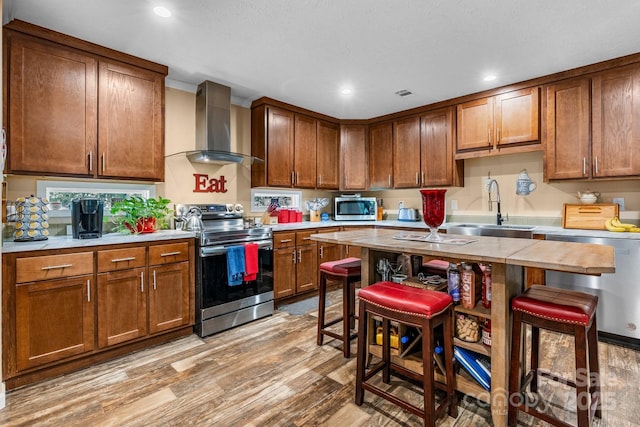 200 Vista Pointe Dr, Stony Point, NC 28678 - kitchen with appliances with stainless steel finishes, wall chimney exhaust hood, light wood-type flooring, light countertops, and recessed lighting