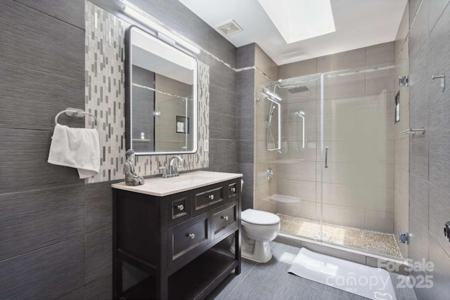 9954 Mitchell Glen Dr, Charlotte, NC 28277 - full bath featuring a shower stall, vanity, a skylight, tile walls, and tile patterned flooring
