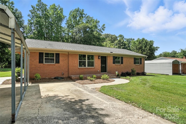 2705 Lowell Bethesda Rd, Gastonia, NC 28056 - ranch-style home featuring brick siding, a front yard, roof with shingles, a storage unit, and concrete driveway