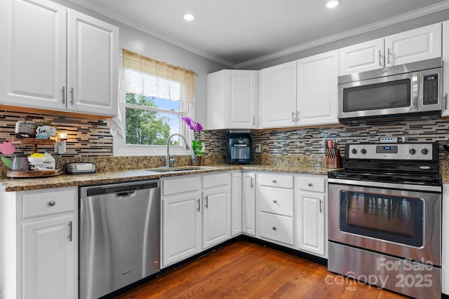3651 16th St NE, Hickory, NC 28601 - kitchen featuring appliances with stainless steel finishes, light stone countertops, white cabinets, decorative backsplash, and crown molding