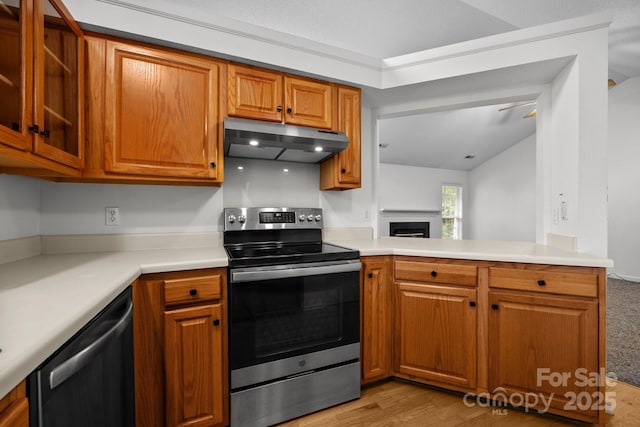 385 Glensprings Dr Unit 269, Fletcher, NC 28732 - kitchen with under cabinet range hood, appliances with stainless steel finishes, brown cabinets, and a fireplace