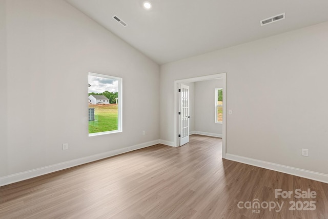 7106 Jerimoth Dr, Charlotte, NC 28215 - empty room with plenty of natural light, vaulted ceiling, wood finished floors, and recessed lighting