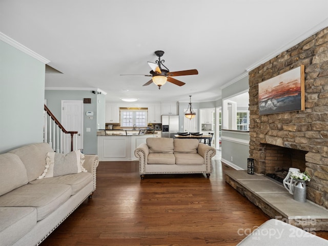 165 Cottontail Ln SE, Concord, NC 28025 - living room featuring ceiling fan, ornamental molding, dark wood-style flooring, a fireplace, and stairway
