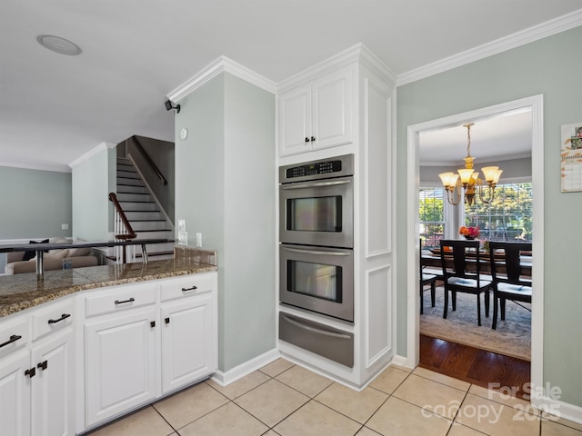 165 Cottontail Ln SE, Concord, NC 28025 - kitchen with a warming drawer, stainless steel double oven, ornamental molding, a chandelier, and white cabinetry