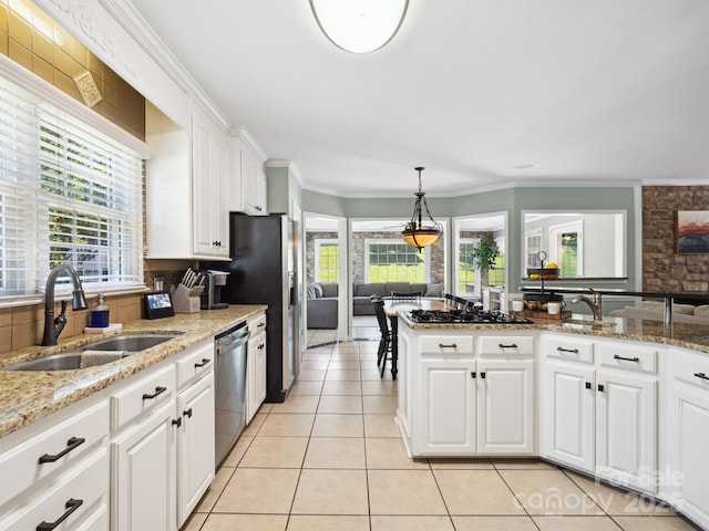 165 Cottontail Ln SE, Concord, NC 28025 - kitchen featuring stainless steel dishwasher, light tile patterned floors, plenty of natural light, white cabinetry, and ornamental molding