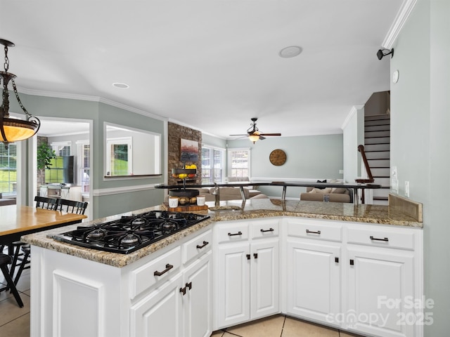 165 Cottontail Ln SE, Concord, NC 28025 - kitchen with black gas stovetop, light tile patterned floors, a ceiling fan, crown molding, and white cabinetry