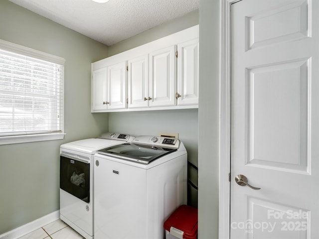 165 Cottontail Ln SE, Concord, NC 28025 - laundry room featuring washer and clothes dryer, cabinet space, a textured ceiling, and light tile patterned floors