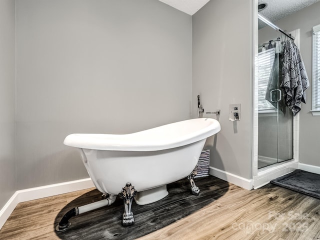 165 Cottontail Ln SE, Concord, NC 28025 - bathroom with wood finished floors, a shower stall, a freestanding tub, and a textured ceiling