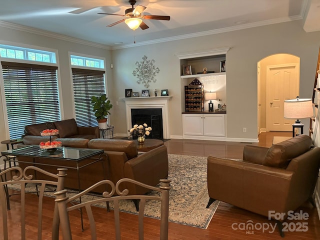 1808 Mill Chase Ln, Waxhaw, NC 28173 - living area featuring a ceiling fan, crown molding, a fireplace, wood finished floors, and arched walkways