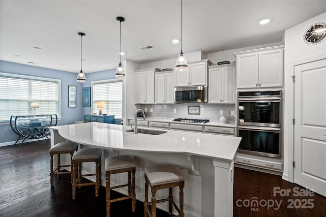 17733 Burnt Hickory Dr, Charlotte, NC 28278 - kitchen featuring appliances with stainless steel finishes, decorative backsplash, white cabinets, a kitchen breakfast bar, and recessed lighting