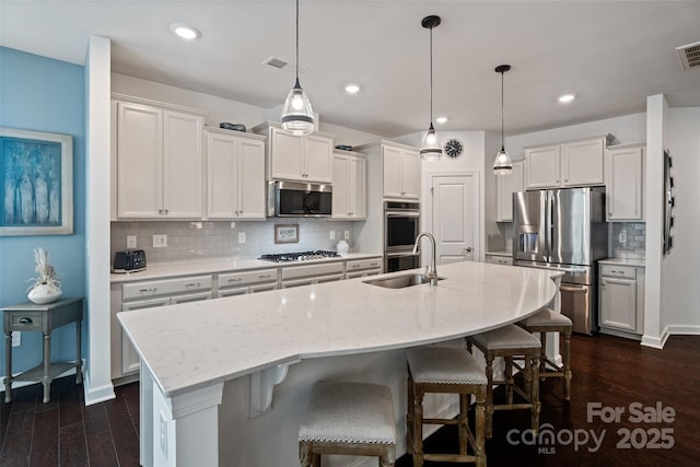 17733 Burnt Hickory Dr, Charlotte, NC 28278 - kitchen featuring stainless steel appliances, tasteful backsplash, an island with sink, dark wood-type flooring, and recessed lighting