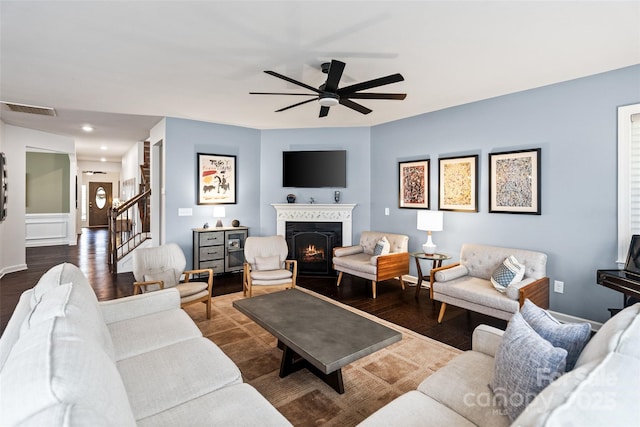17733 Burnt Hickory Dr, Charlotte, NC 28278 - living area featuring ceiling fan, a warm lit fireplace, dark wood-style floors, and stairs